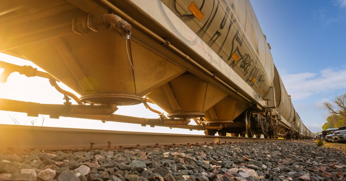 Low-angle view of a freight train with sunlight shining through, captured in Reads Landing, MN.